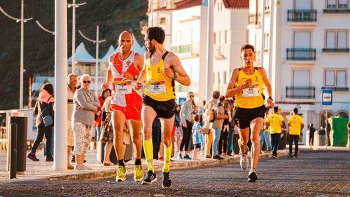 Free Runners participate in a city marathon during a sunny day, showcasing athleticism and determination. Stock Photo