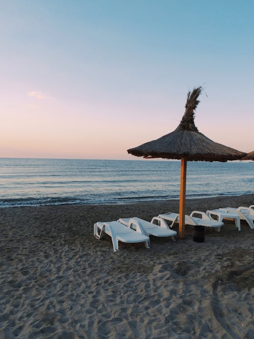 免费 日光躺椅在海边沙滩上的照片 素材图片