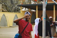 一个快乐的穿着红色衬衫、戴着帽子的男人在户外微笑着与朋友们在一起