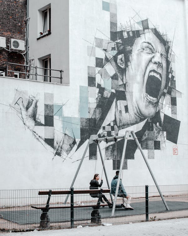 Photo of Two People Sitting on Swings