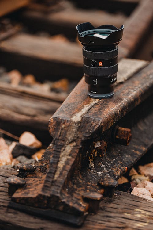 A camera lens sitting on top of a wooden train track