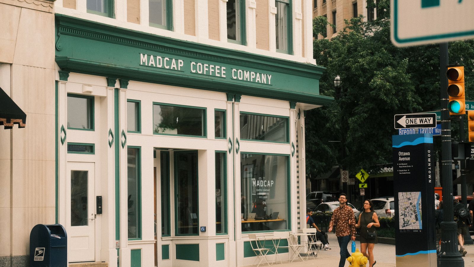 A couple walks past Madcap Coffee Company in downtown Grand Rapids, Michigan.
