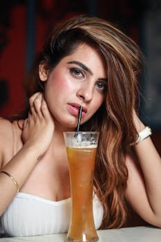 室内，一个年轻女子用吸管品尝冰饮料的肖像引人注目