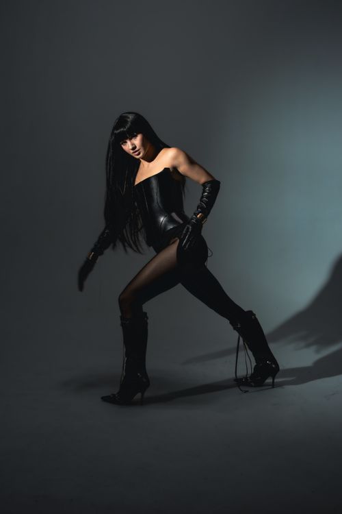 Free A woman in black leather fashion poses dramatically in a studio setting. Stock Photo