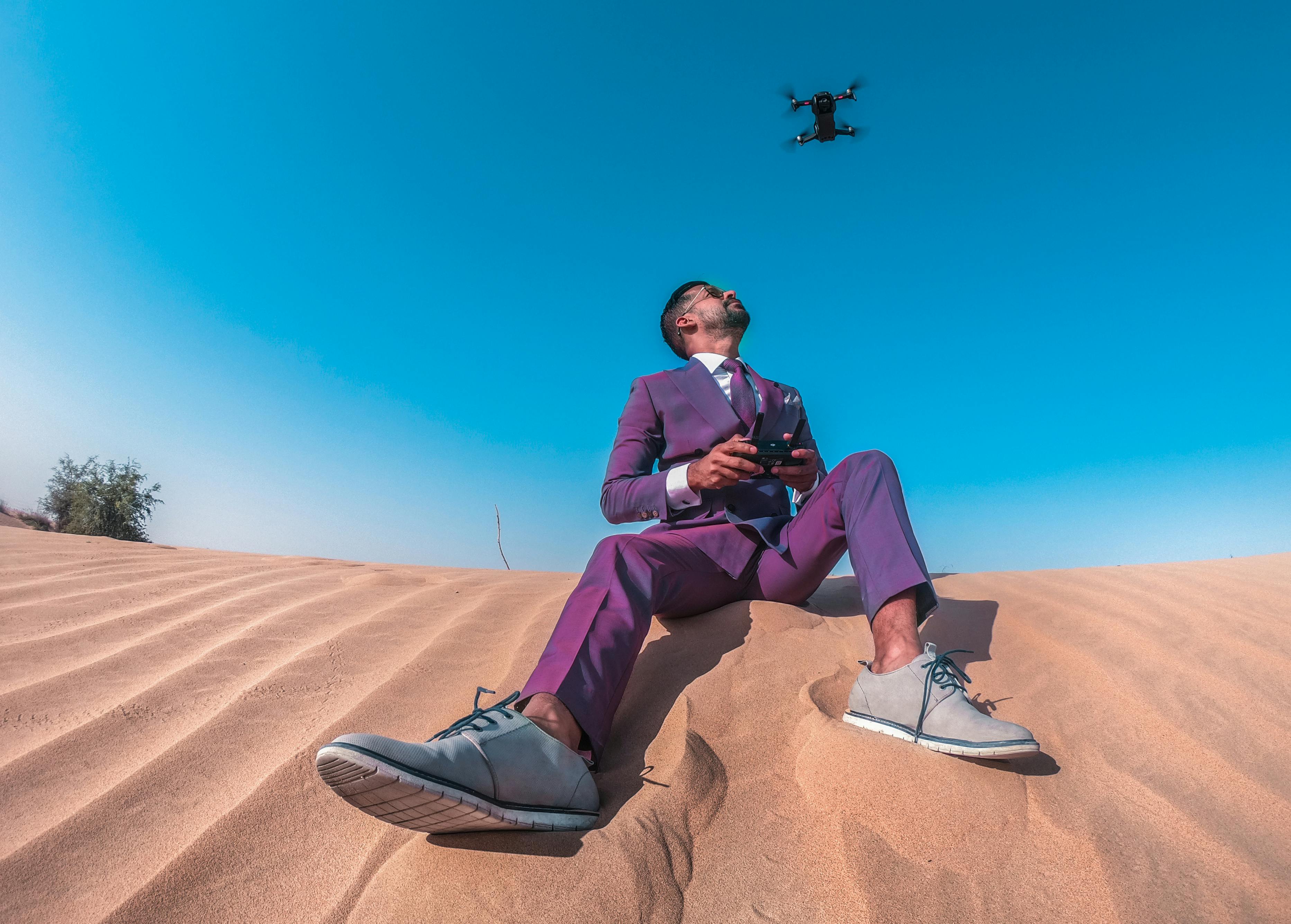 low angle photo of man sitting on sand