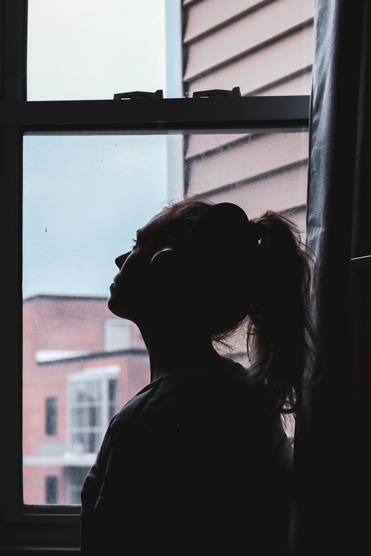 Silhouette Photo Of A Woman Looking Through Window