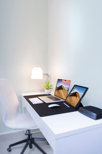 Escritorio de oficina en casa con estilo, pantallas duales y decoración minimalista. Perfecto para el trabajo remoto y la productividad.