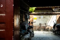 Red Bicycle Parked Besides Brown and White Wall