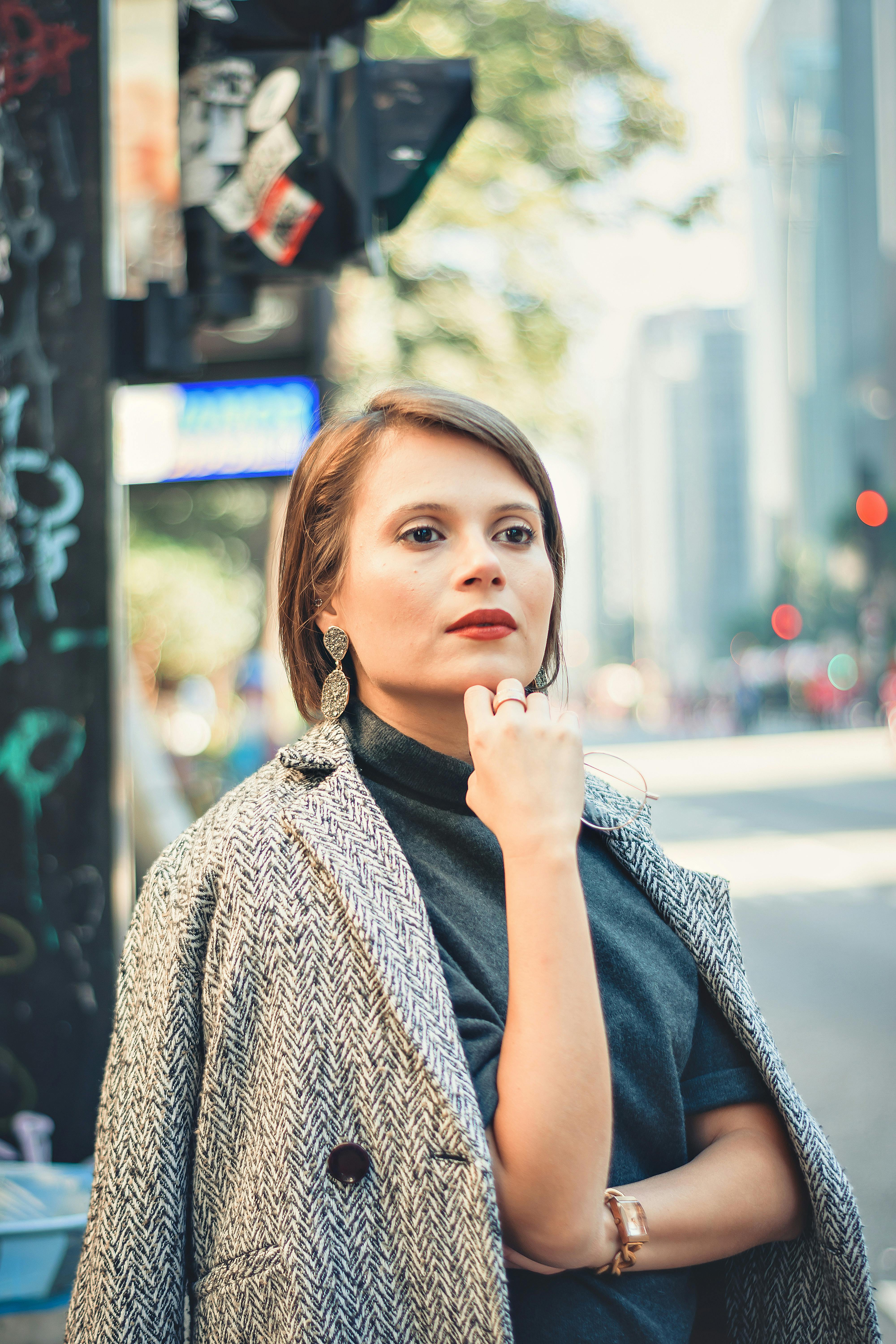 繁华的城市街道上，时尚女性自信地站立，尽显都市风范与优雅
