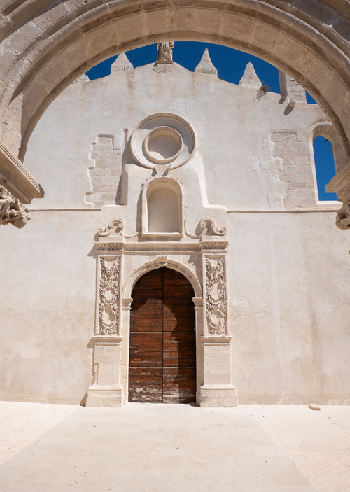 Free Close-up view of an ornate church doorway with detailed carvings under an arched sky, showcasing ancient architecture. Stock Photo