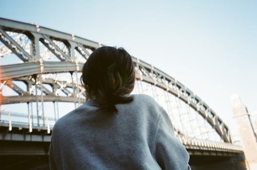 一名女子站在城市钢桥下，被人从后面抓获