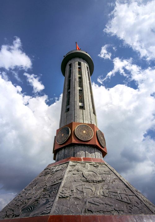 Free Lung Cu Flag Tower stands tall against a bright blue sky, showcasing its unique architectural design. Stock Photo