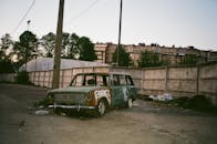 黄昏时分，一辆古董车被遗弃在一个布满涂鸦的城市街区