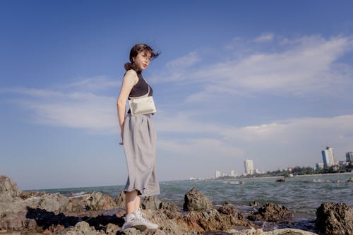 Foto De Mujer De Pie Sobre Rocas Por Cuerpo De Agua