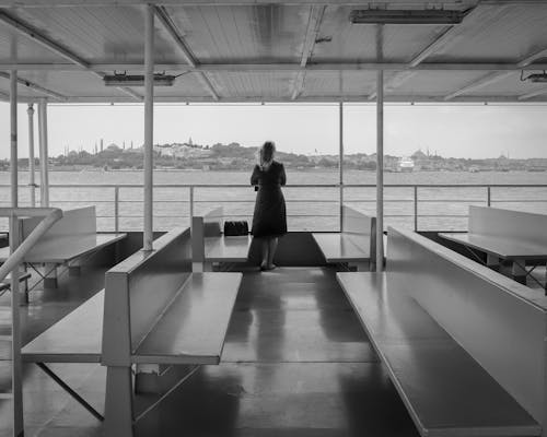 A woman standing on a boat looking out at the water