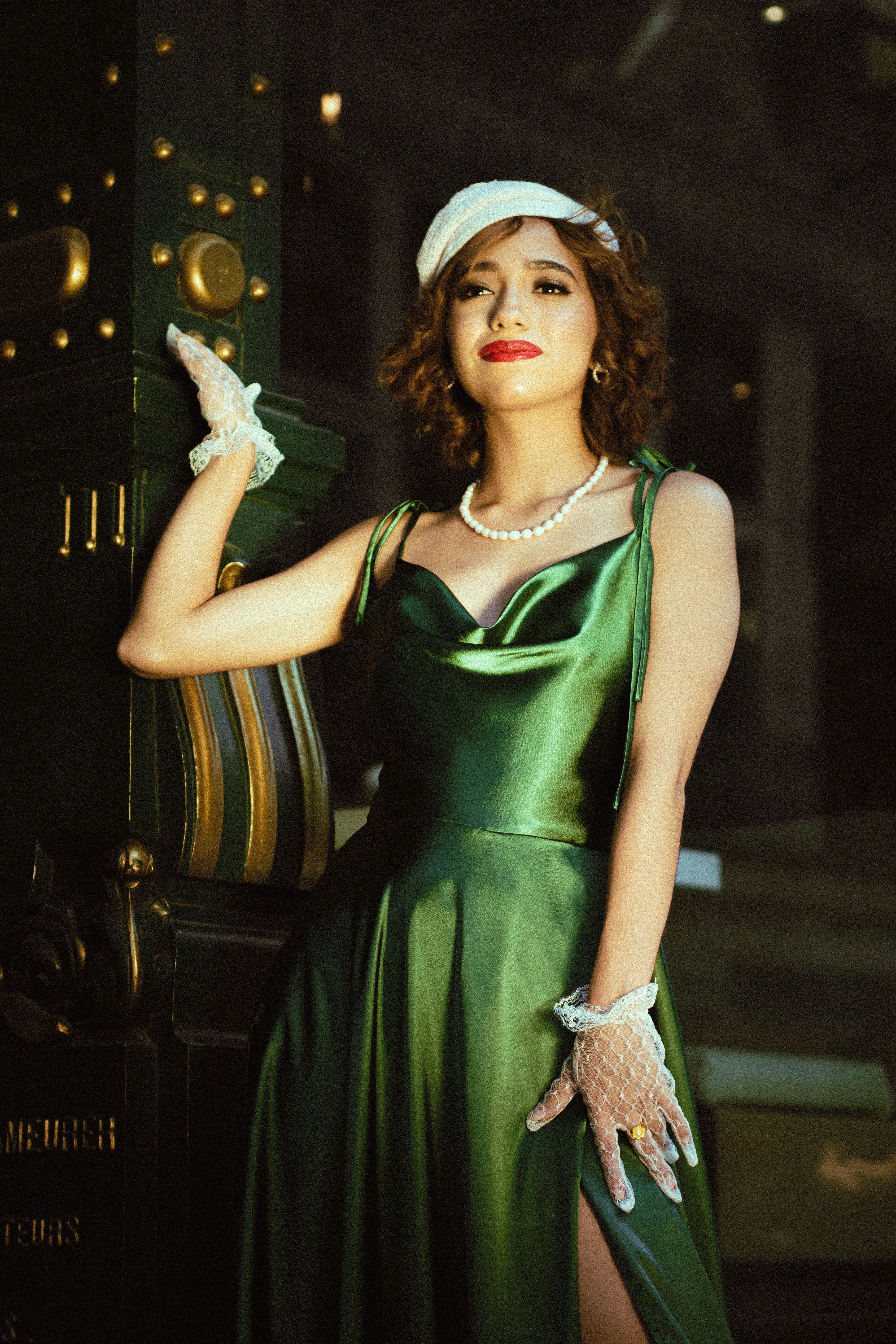 Stylish woman in green dress and white gloves striking a vintage pose outdoors in Puebla.
