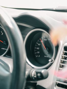 A detailed view of a car dashboard with focus on the speedometer showing speed in kilometers per hour.