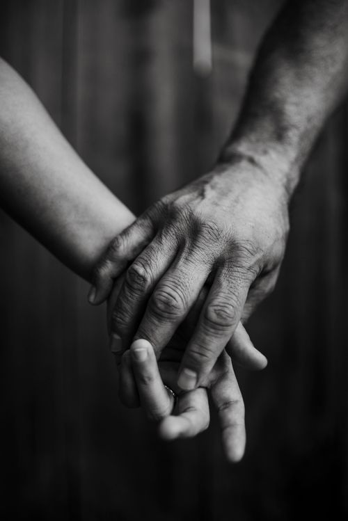 Free Close-up of a couple's hands holding in a soft, intimate black and white setting. Stock Photo
