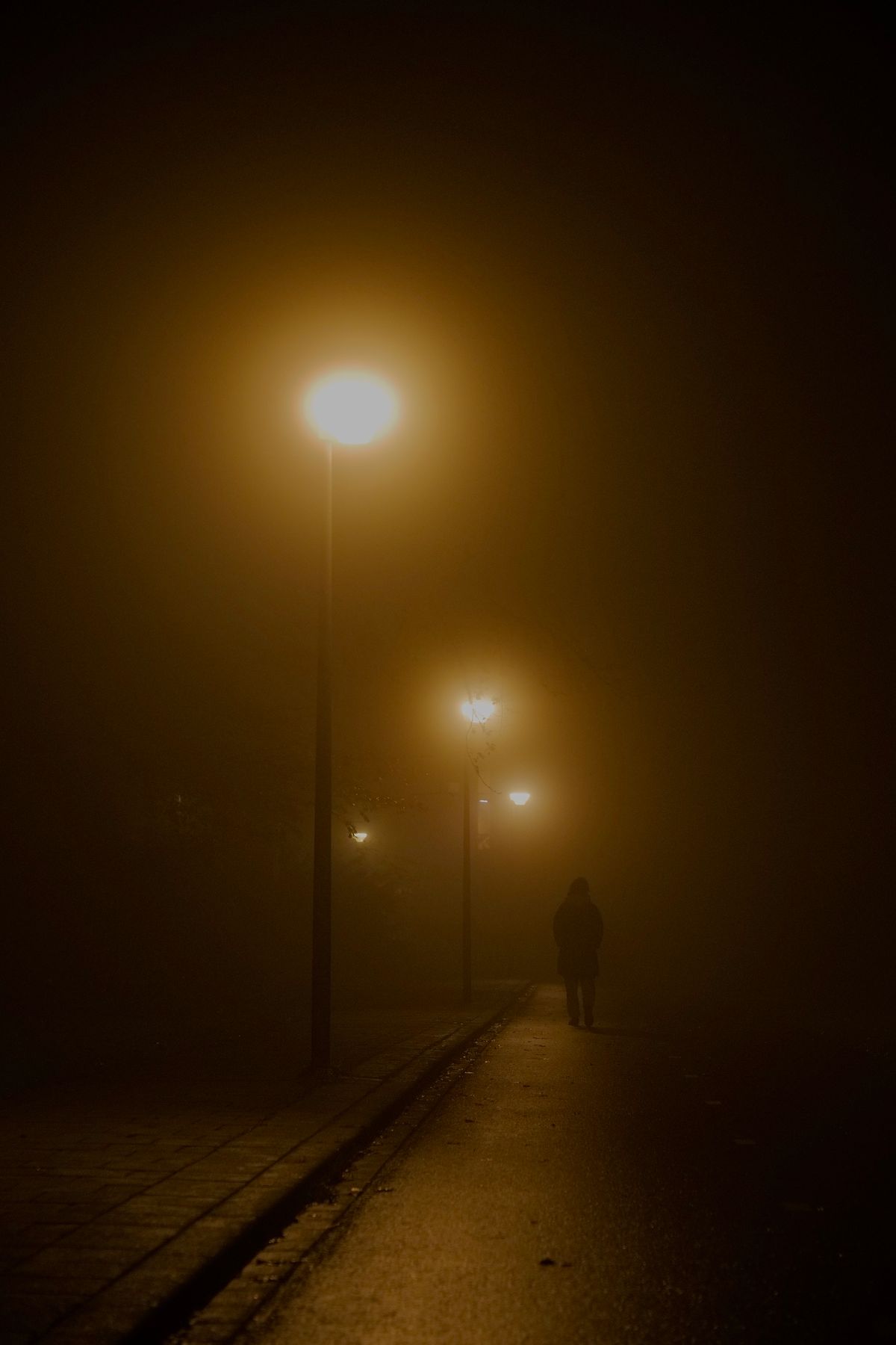 Person walking away along a quiet street at night