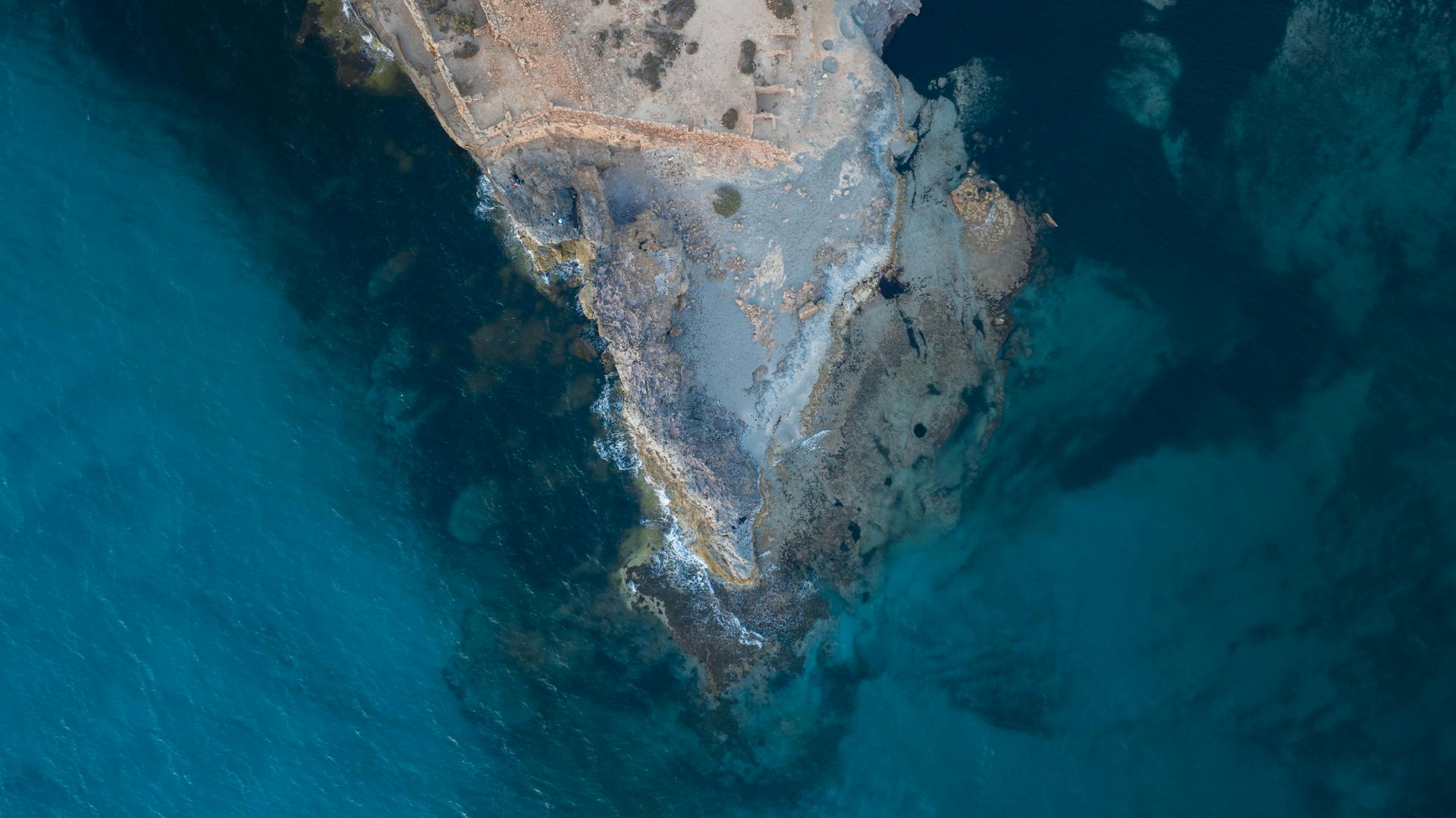 Stunning aerial shot of Libyan rocky coastline with clear blue waters, showcasing natural beauty.