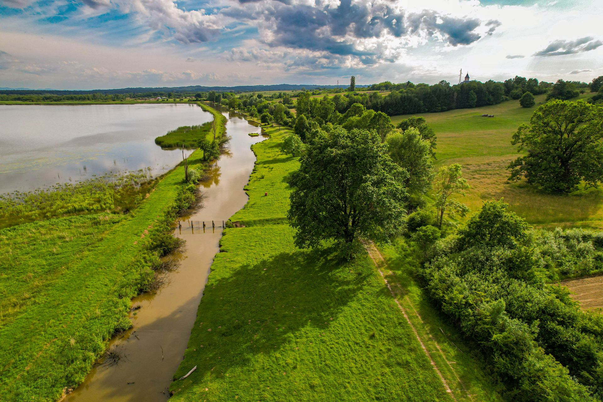 Discover the beauty of Kaniška Iva with this stunning aerial view of a lush green landscape and tranquil water body.