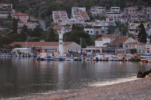 Free Serene harbor scene in Foça, İzmir with boats and hillside houses at dusk. Stock Photo