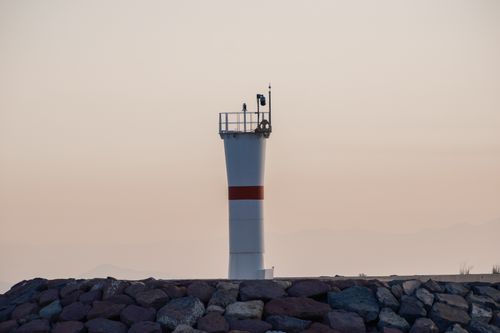 Free A serene lighthouse standing tall against the evening sky in Foça, İzmir, Türkiye. Stock Photo