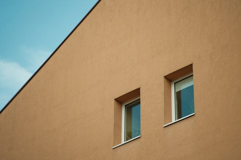 A building with two windows and a blue sky