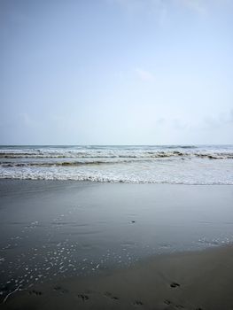 Calm beach scene with gentle waves and a clear sky at the horizon, perfect for relaxation.