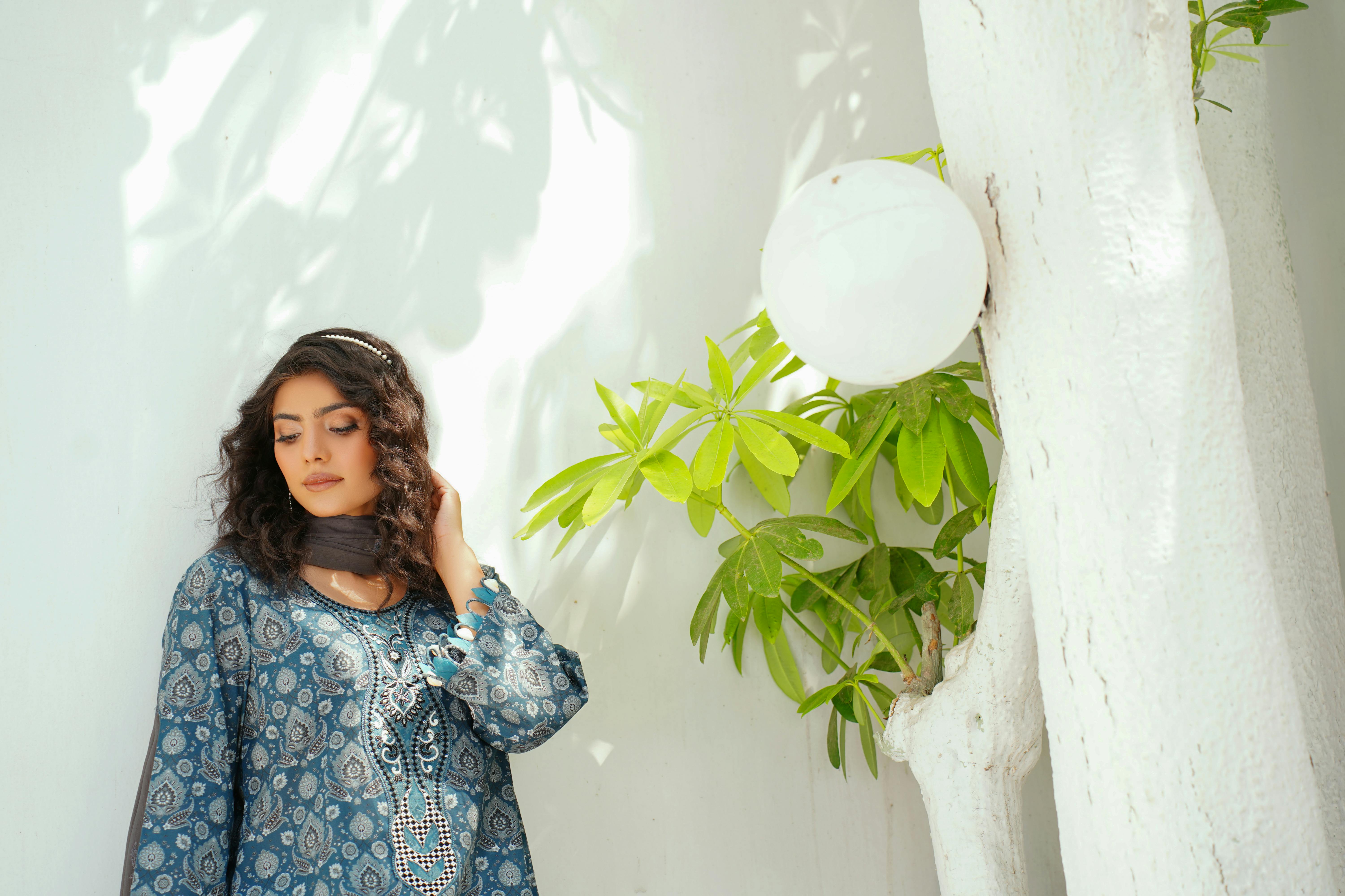 woman standing near tree in traditional clothing