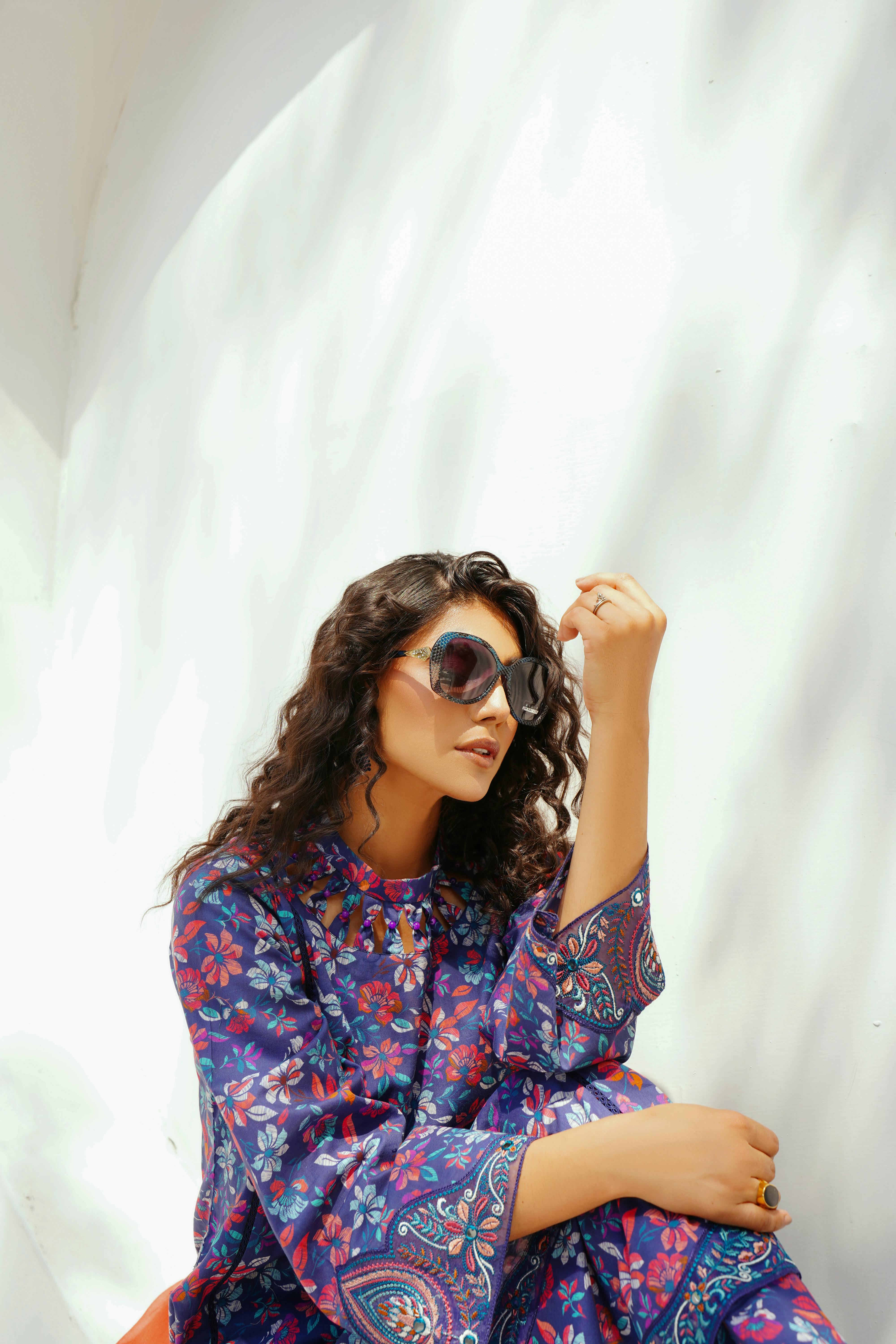 portrait of woman sitting in sunglasses and traditional clothing