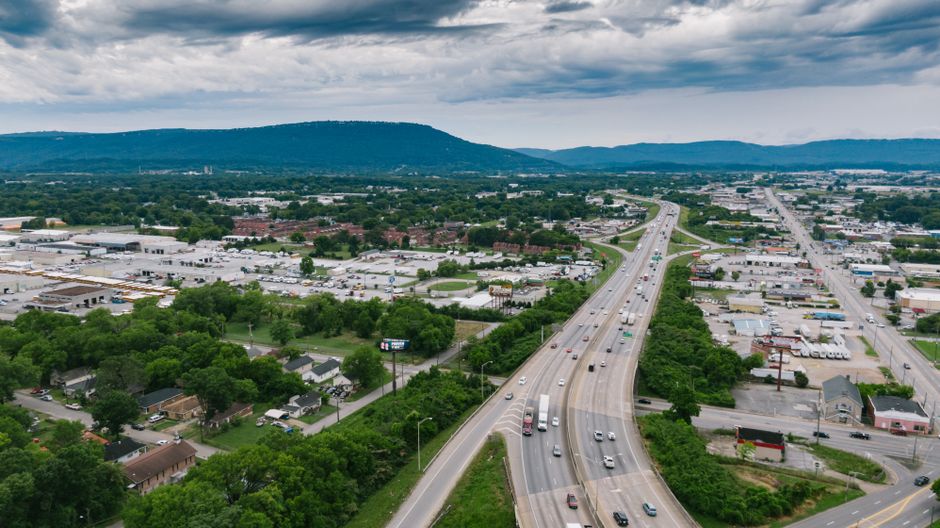 Breathtaking Nashville Helicopter Tour: Quick Hop Review — Your Aerial Adventure Over Music City Review 2026 - Aerial view of a busy highway in Chattanooga with lush greenery and urban landscape under cloudy skies.