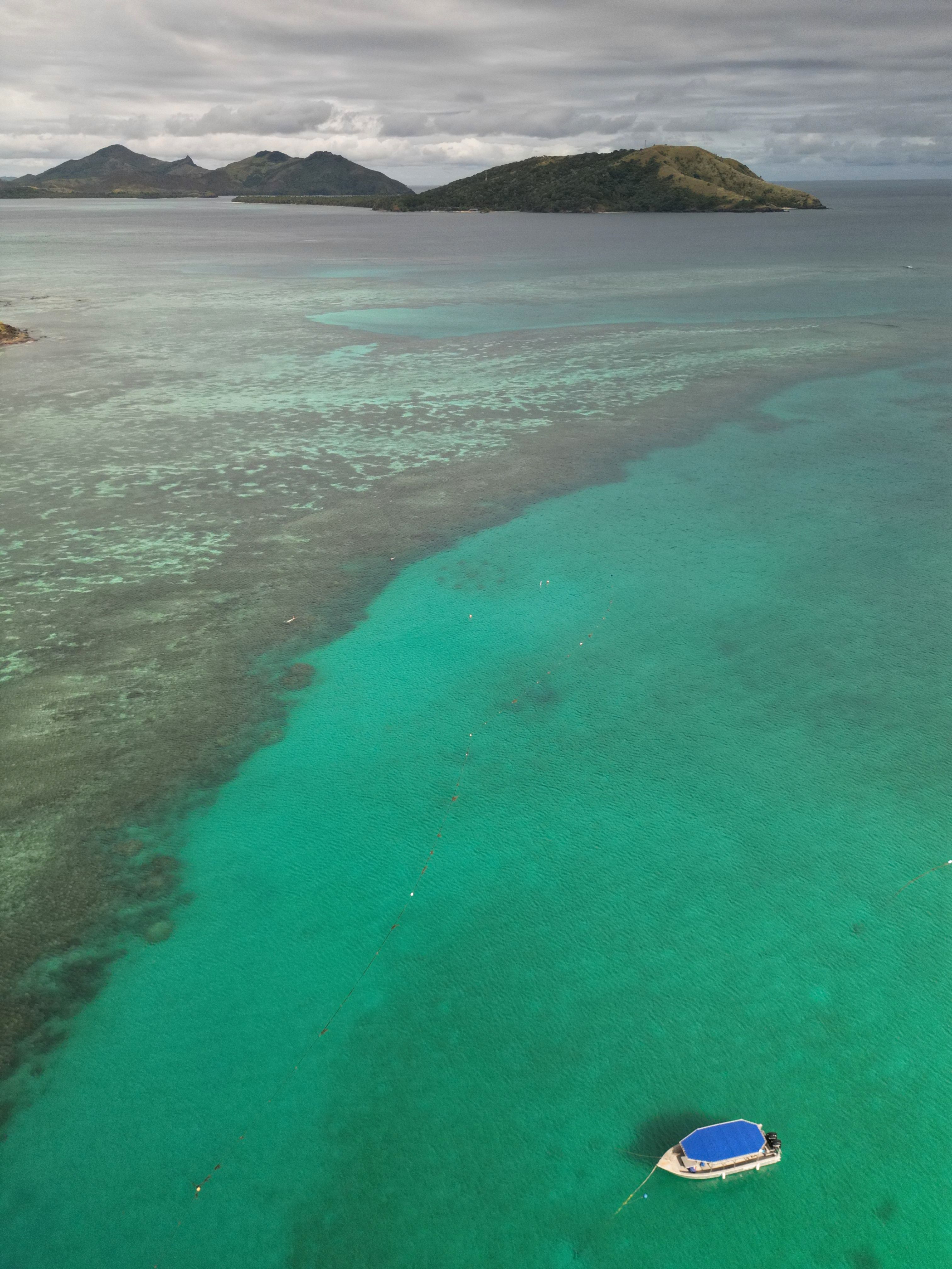 Aerial View of a Boat on a Body of Water and Mountains in the Distance ...