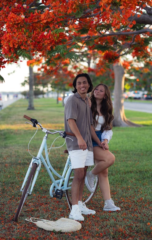 A couple posing for a picture on a bike