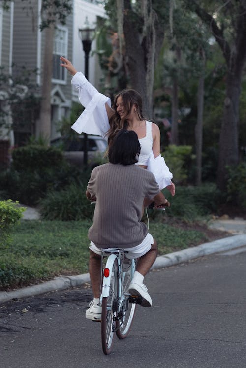 A man and woman are riding a bike together