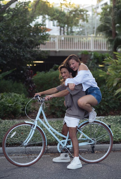 A woman is riding a bike with a man on top
