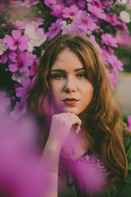 Selective Focus Photo of Woman Near Purple-Petaled Flowers