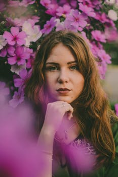 这幅宁静的女人肖像，被鲜艳的紫色花朵环绕，更凸显了她的美丽