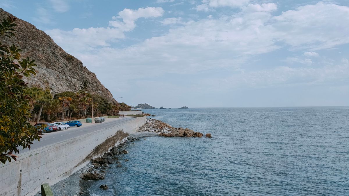 Drum de coastă șerpuind pe lângă marea albastră, road trip spre Grecia