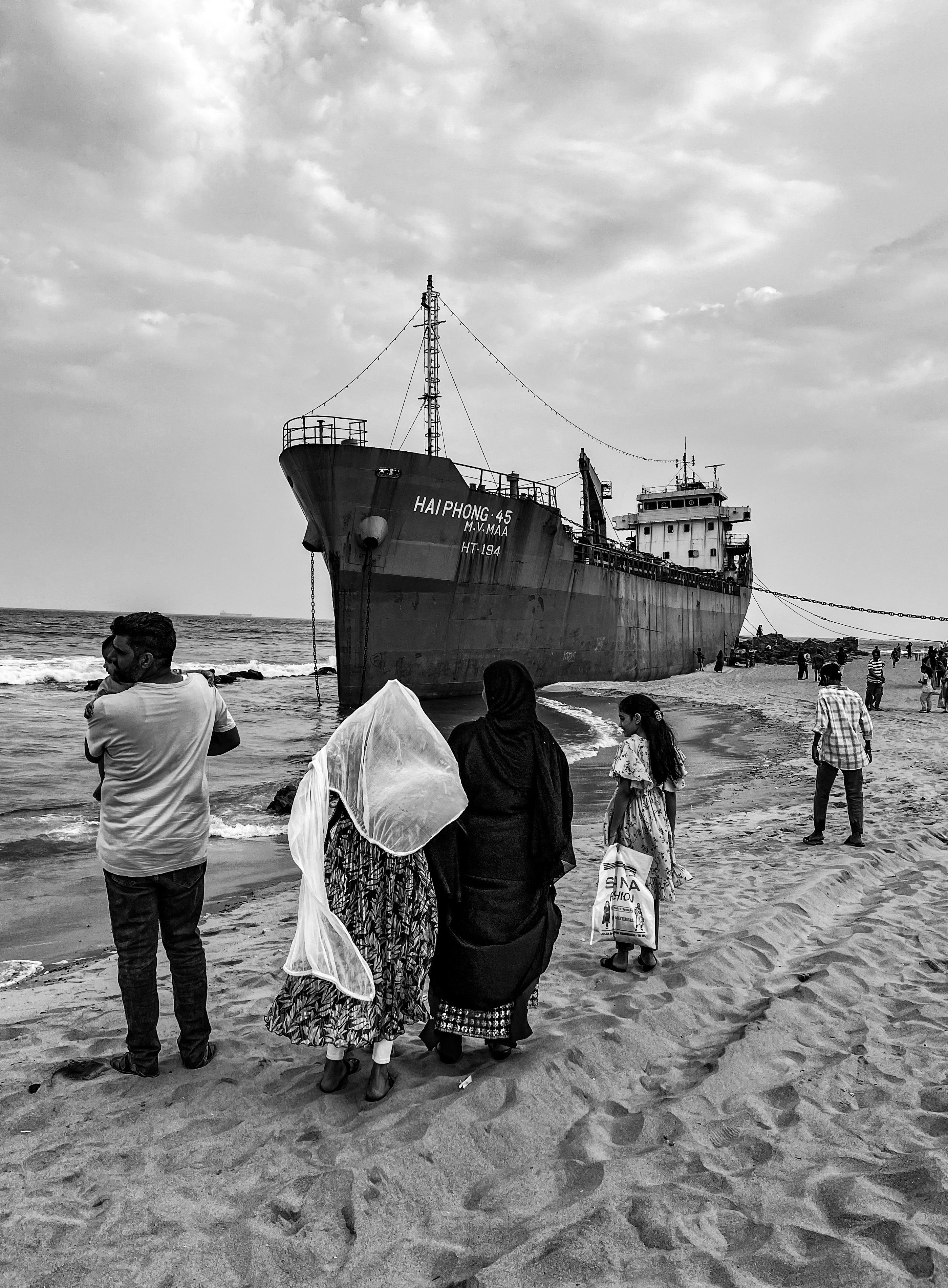 People and Cargo Ship Moored on Seashore · Free Stock Photo
