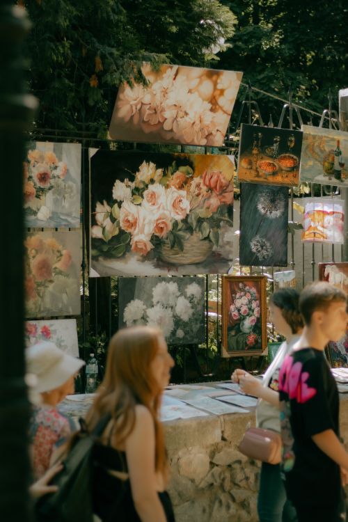 Free Vibrant street art with floral paintings on display in a bustling urban setting. Stock Photo