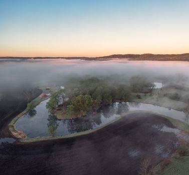 Drone captures foggy Wabasha landscape at sunrise, highlighting serene nature.
