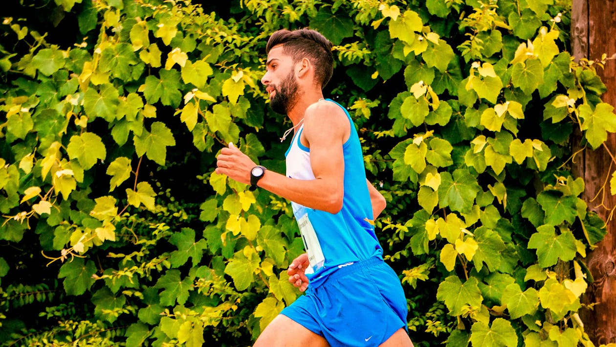 Photo of Man Running Beside Plants