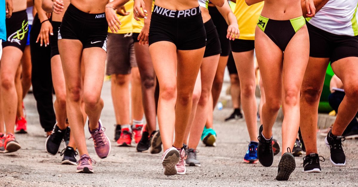 A group of runners participating in an outdoor street marathon wearing athletic gear.