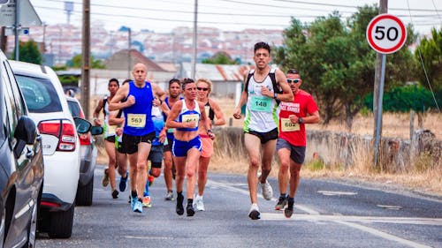 Free Photo of People Running Beside Parked Vehicles Stock Photo