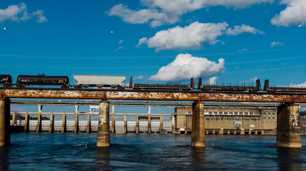 A train crosses a rusty bridge over the Tennessee River in Chattanooga under a clear blue sky.