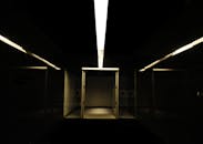 地下走廊黑暗而喜怒无常，配有引人注目的线性照明和钢门