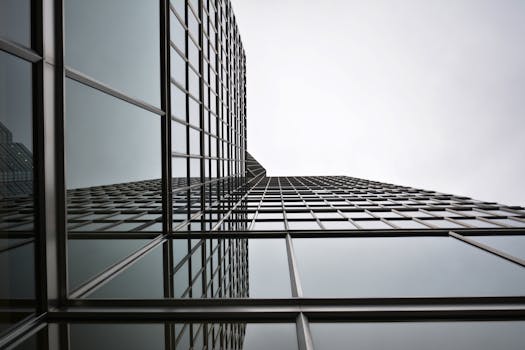 低角度视角下的城市环境中，带有反光板的现代玻璃摩天大楼