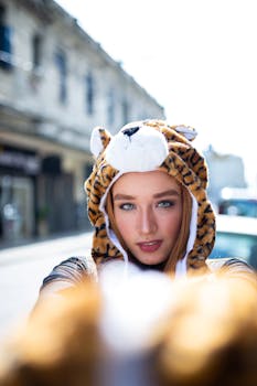 一名绿眼睛的年轻女子戴着可爱的动物主题帽子在户外摆姿势