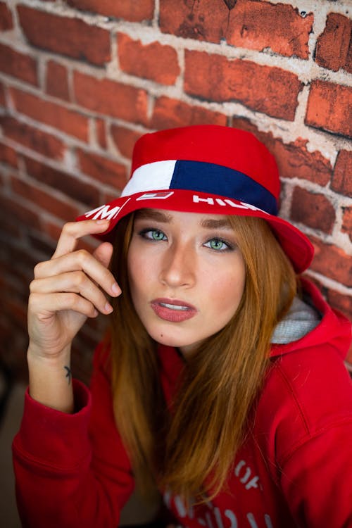 Photo of Woman Sitting Against Brick Wall